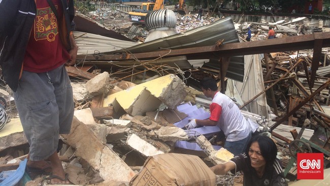 Pemilik pabrik dan puluhan karyawan mengais puing-puing pabrik mencari alat-alat produksi yang kemungkinan masih layak untuk dibawa pulang.