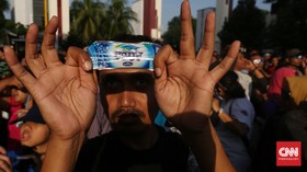 Polah Warga Jakarta Nikmati Gerhana Lewat Plastik Air Mineral
