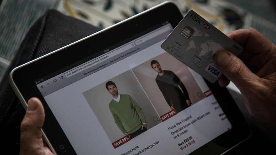 BRISTOL, UNITED KINGDOM - AUGUST 11:  In this photo illustration a man uses a credit card to buy something online on August 11, 2014 in Bristol, United Kingdom. This week marks the 20th anniversary of the first online sale. Since that sale - a copy of an album by the artist Sting - online retailing has grown to such an extent that it is now claimed that 95 percent of the UK population has shopped online and close to one in four deciding to shop online each week.  (Photo Illustration by Matt Cardy/Getty Images)
