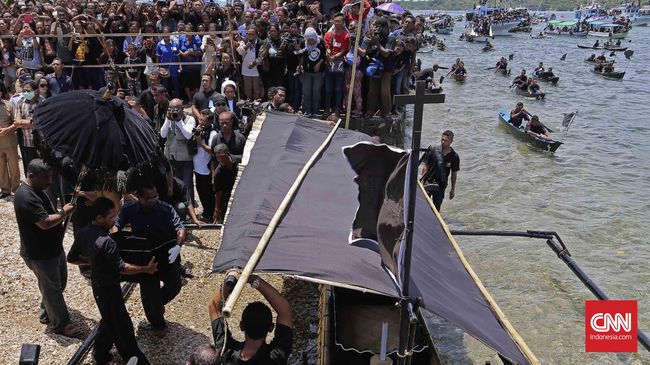 Sampan-sampan kecil mengiringi perahu pembawa patung bayi Yesus. Lantunan doa terdengar di Selat Larantuka sepanjang arak-arakan laut pada Jumad Agung.