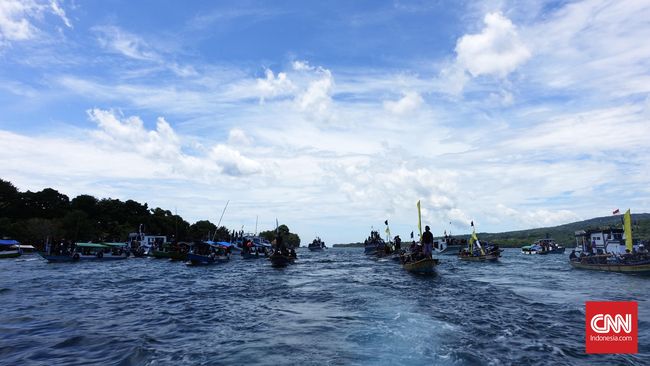Puluhan kapal menyeruak dari arah Karang Serbete menuju Selat Larantuka. Satu tujuan mereka, mengarak Tuhan Meninu.