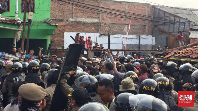 Warga melempari petugas dengan batu dan kayu dan meminta petugas menghentikan penggusuran pada rumah-rumah mereka.