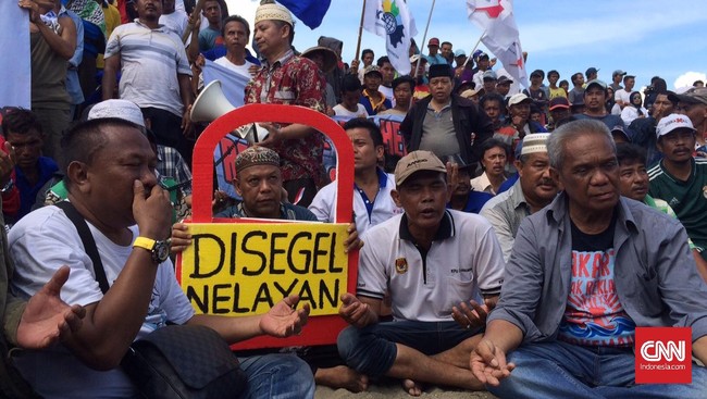 Unjuk rasa nelayan untuk menolak reklamasi Teluk Jakarta juga diwarnai oleh aksi timbun badan dengan pasir oleh seorang wanita paruh baya di atas Pulau G.