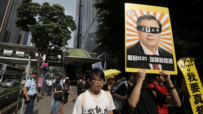 Ratusan demonstran Hong Kong berarak di salah satu ruas jalan sambil meneriakkan slogan pro demokrasi menjelang kunjungan langka salah satu pejabat China.