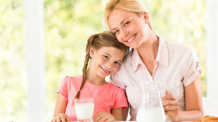Susu Little girl drinking milk with her mother.