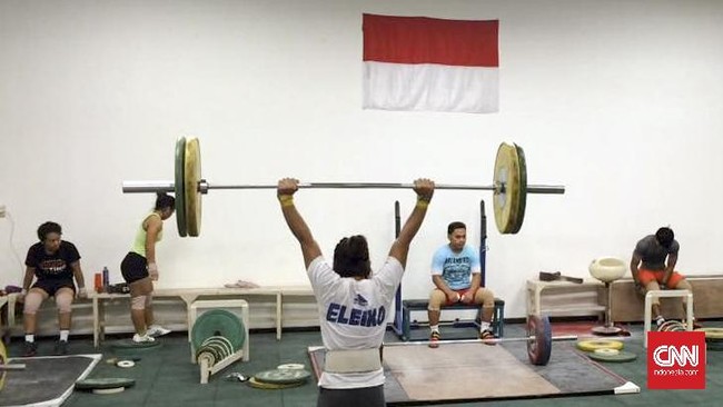 Pada tujuh pagi waktu setempat, secara mendadak kamar tim angkat besi Indonesia didatangi dua orang petugas doping yang melakukan tes secara acak.