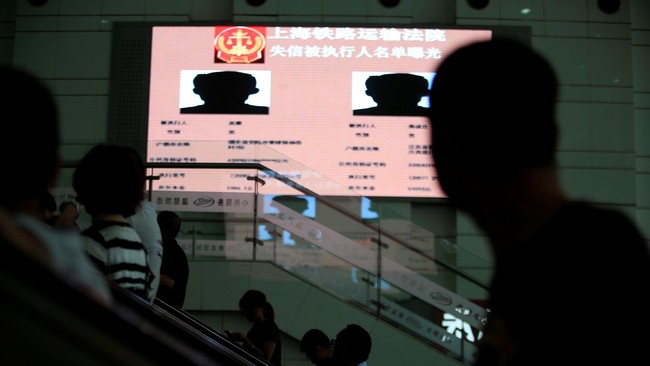Pengadilan di China memajang nama-nama, foto, dan alamat para penunggak utang di papan iklan stasiun kereta.
