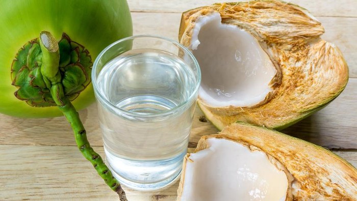 coconut water and fresh coconut on wooden background