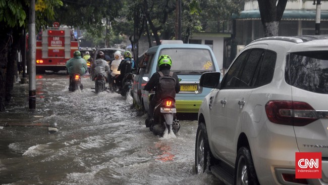 Saat pengendara kendaraan roda empat melalui banjir, sebaiknya tetap jaga jarak aman antara genangan dengan saluran pembuangan.