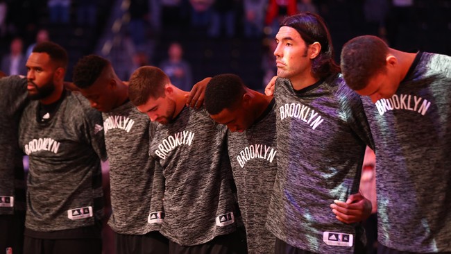 Tim basket Brooklyn Nets saling menggenggam lengan saat lagu kebangsaan AS diperdengarkan sebagai simbol solidaritas di tengah krisis sosial Negara Paman Sam.