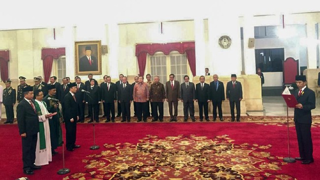 Dengan mengenakan pakaian formal dan peci hitam, Jokowi mengambil sumpah Ignasius Jonan dan Arcandra Tahar.