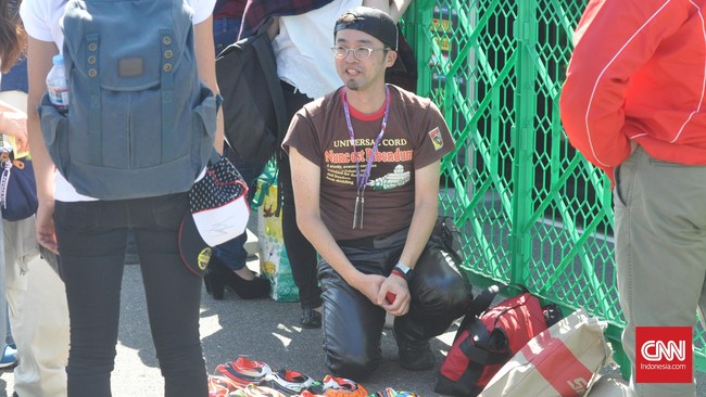 Di tengah keriuhan para penggila MotoGP Jepang di Sirkuit Motegi, seorang pedagang topeng Kabuki nekat menjajakan dagangannya.