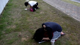 Seorang Wanita Thailand Didesak Berlutut di Depan Foto Raja