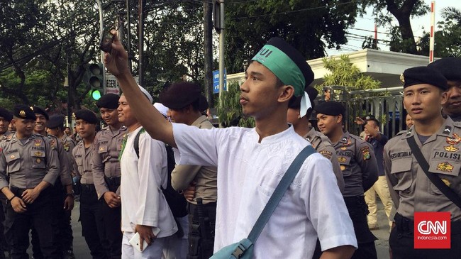 Tak semua peserta serius mendengarkan orasi dan berteriak yel-yel. Beberapa pemuda sibuk selfie dan saling bergantian mengambil foto.