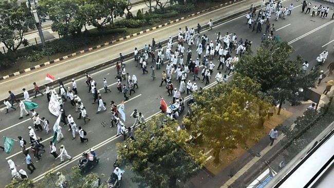 Massa berteriak takbir dan membaca syahadat. Mereka membawa spanduk yang dibawa dituliskan ‘Tegakkan hukum dan keadilan. Tangkap dan penjarakan Ahok'.