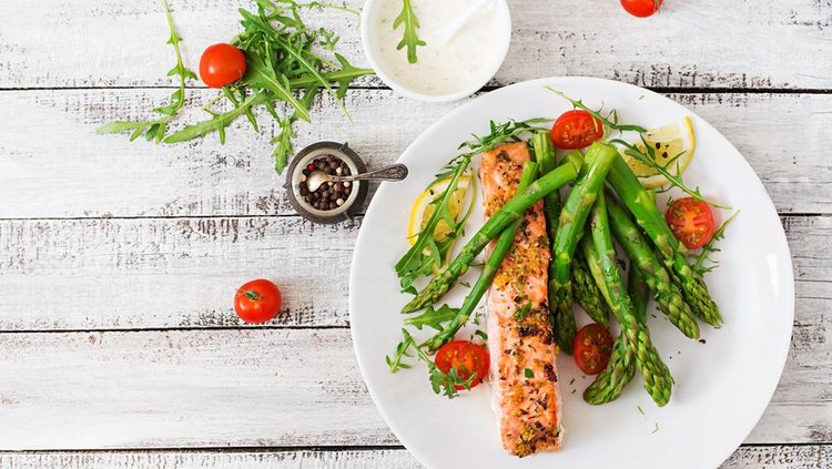 Salmon panggang Baked salmon garnished with asparagus and tomatoes with herbs. Top view