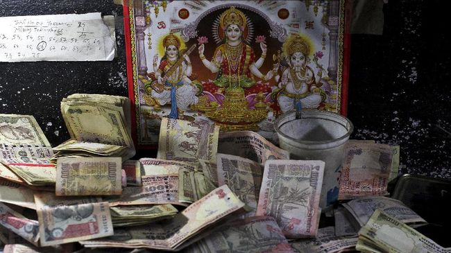 Sejumlah wisatawan mengamen di jalanan, demi mendapatkan uang fisik yang peredarannya semakin langka di India.