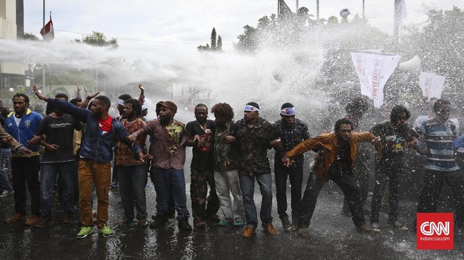 Polisi menembakkan water canon ke arah massa Front Rakyat Indonesia yang menuntut referendum Papua.