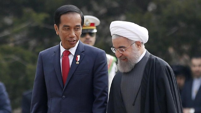 Iran's President Hassan Rouhani welcomes Indonesia's President Joko Widodo (L) during a ceremony at Saad Abad palace in Tehran on December 14, 2016. / AFP PHOTO / ATTA KENARE