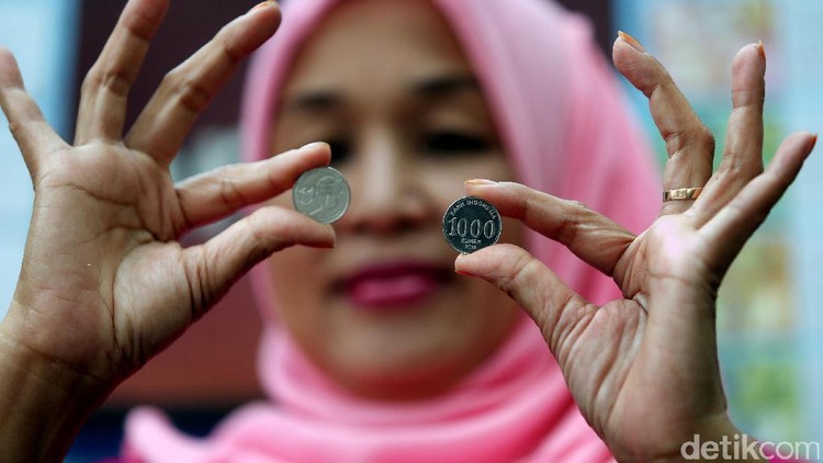 Usai antre untuk menukarkan uang, sejumlah warga memamerkan uang rupiah baru.