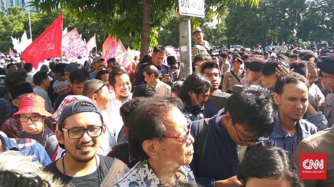 Polisi mengimbau massa tidak memaksa masuk ruang sidang karena sudah melebihi batas kapasitas 80 orang.