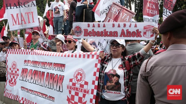 Selain bernyanyi, massa pendukung Ahok juga mengibarkan bendera Merah Putih dan menunjukkan sejumlah spanduk dukungan terhadap Ahok.