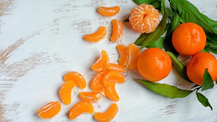 Ripe tangerines and tangerine slices on canvas kitchen towelsRipe tangerines and tangerine slices on canvas kitchen towels