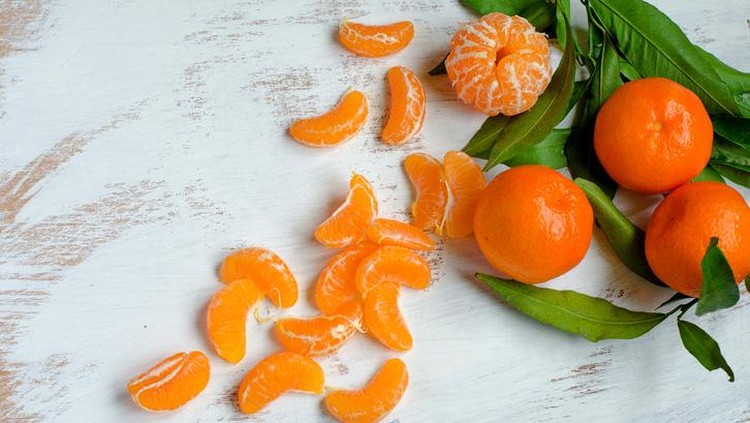 Ripe tangerines and tangerine slices on canvas kitchen towelsRipe tangerines and tangerine slices on canvas kitchen towels