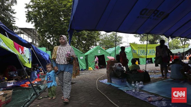Sejumlah warga mengungsi di tenda darurat di Halaman Gereja Sion, Jakarta, Selasa 10 Januari 2016. Sebanyak 135 Kepala Keluarga (KK) atau 365 jiwa warga korban kebakaran 120 rumah di RT 02/04, Pinangsia, Taman Sari, Jakarta Barat masih bertahan di tenda pengungsian yang didirikan di halaman Gereja Sion. CNN Indonesia/Adhi Wicasono