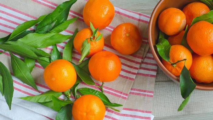 Ripe tangerines and tangerine slices on canvas kitchen towelsRipe tangerines and tangerine slices on canvas kitchen towels