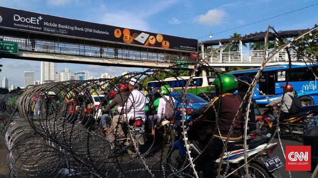 Petugas keamanan menutup sementara jalur masuk ke kawasan bisnis SCBD, selama demo massa FPI mengawal Rizieq Shihab berlangsung di Polda Metro Jaya.
