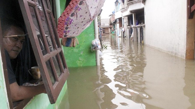 Wati, 68 tahun, berjalan kaki tiga jam untuk mengungsi ke rumah adiknya, Selasa (25/2) pukul 03.00 WIB dini hari, akibat banjir menerjang rumahnya di Bekasi.