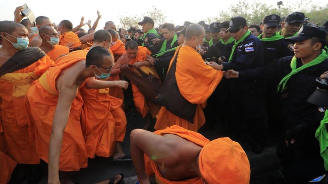 Kepolisian Thailand memerintahkan ribuan umat keluar dari Dhammakaya demi memburu Phra Dhammachayo, mantan pemimpin biara, buron kasus pencucian uang.