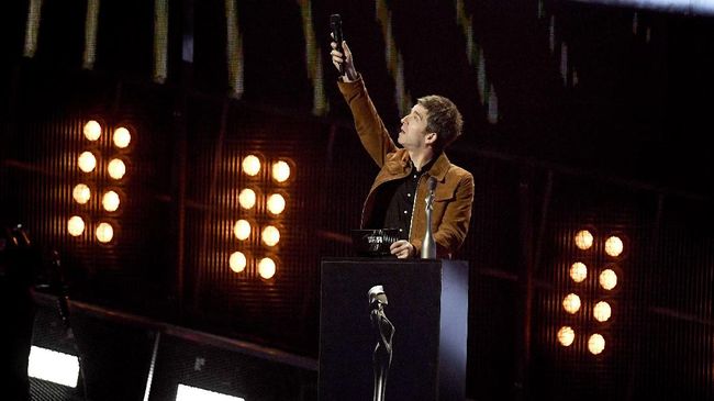 Noel Gallagher meminta seseorang untuk mendampinginya di atas panggung sembari memainkan gunting. Meski terdengar lucu, gunting dimainkan dengan serius.