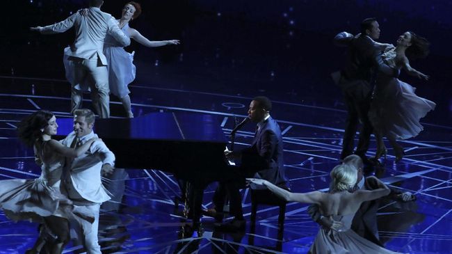 John Legend tampil memainkan piano sambil menyanyikan dua lagu tema La La Land: City of Stars dan Audition (The Fools Who Dream).