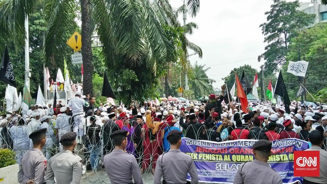 Massa kontra Ahok melempar batu dan botol minuman ke arah polisi sembari berlari.