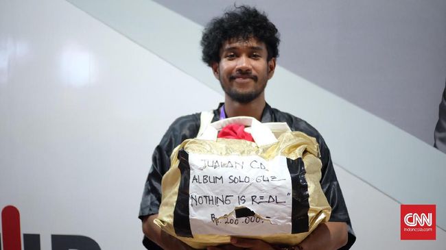 Teddy Adhitya, yang sudah menjadi penampil di Java Jazz Festival selama tujuh tahun, menenteng tas besar berisi CD musiknya, untuk dijajakan.