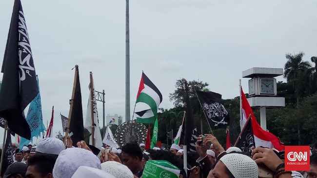 Selain bendera Palestina, tampak seorang peserta aksi menggunakan kaos dengan simbol ISIS atau Negara Islam di Irak dan Suriah (ISIS).