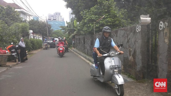 Anies Baswedan menunggangi Vespa Sprint bernomor polisi AB 6182 FA berwarna abu-abu bersama sang putra, Ismail Hakim Baswedan.
