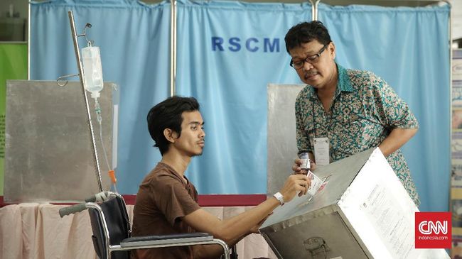 Seorang pasien memasukan surat suara ke kotak suara pada pelaksanaan Pilkada DKI Jakarta putaran kedua di TPS 15 RSCM Jakarta, Rabu (19/4). (CNN Indonesia/ Hesti Rika)