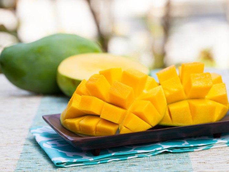 Fresh tropical fruit smoothie mango juice and fresh mango on a outdoor tropical background Copy space