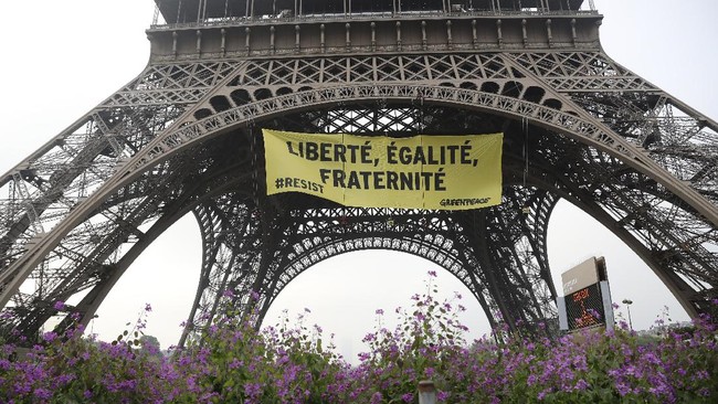 Organisasi pemerhati lingkungan Greenpeace memasang spanduk di Menara Eiffel, memprotes program capres Perancis Marine Le Pen.