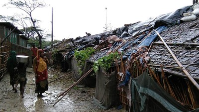 Rohingya refugees walk next to huts in a makeshift camp in Bangladesh's Cox's Bazar district on May 30, 2017 after Cyclone Mora made landfall in the region.
Cyclone Mora hit Bangladesh on May 30, packing winds of up to 135 kilometres (84 miles) per hour, damaging thousands of homes as more than 300,000 people fled villages in the coastal district of Cox's Bazar, which bore the brunt of the cyclone. The district is home to 300,000 Rohingya refugees, most of whom live in flimsy makeshift camps after fleeing persecution in neighbouring Myanmar.  / AFP PHOTO / STR