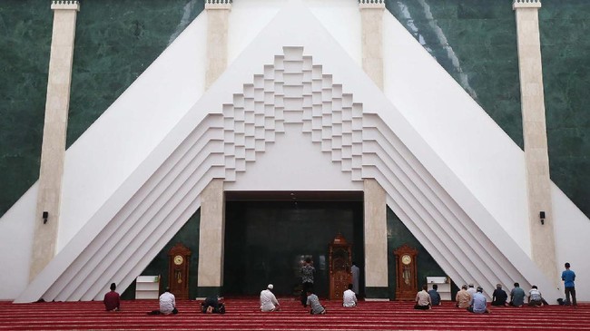 Warga berdoa dan beraktifitas di Masjid Raya KH Hasyim Asyari, Jakarta, Selasa (30/5). Masjid yang digagas oleh Presiden Jokowi itu mampu menampung hingga 12.500 jemaah. Desain masjid terbilang unik dan tidak lazim yakni dengan mengadopsi gaya arsitektur lokal, tropis dan Timur Tengah. Garis segitiga di bagian dalam masjid menjadi pemandangan tidak biasa dan terbilang baru. Pagar dan void dibuat ala arsitektur Betawi. Sementara aroma Timur Tengah terasa dari menara masjid. (Ari Saputra/detikcom)