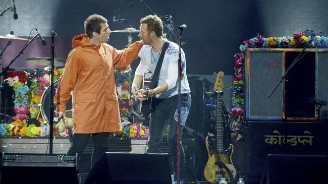 Vokalis Coldplay Chris Martin membela absennya gitaris Oasis Noel Gallagher di konser Manchester. Padahal, adik Noel, Liam, berang atas kelakuan kakaknya itu.