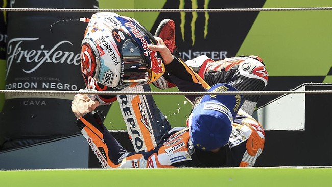 Marc Marquez merayakan finis kedua di GP Katalonia dengan berguling-guling di parc ferme dan podium, menirukan insiden terjatuh karena tersandung papan starter.