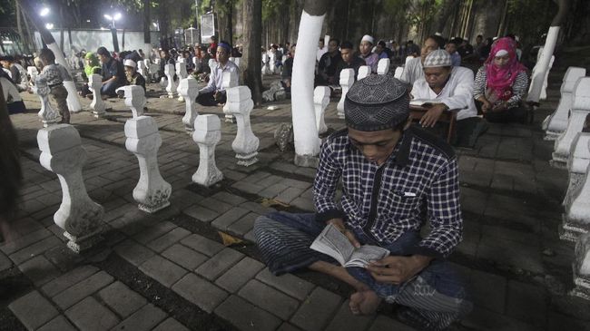 Umat muslim membaca Alquran di kawasan Makam Sunan Ampel, Surabaya, Jawa Timur, Kamis (15/6). Pada malam ke-21 Bulan Ramadan 1438 Hijriyah, kawasan Masjid dan Makam Sunan Ampel tersebut dikunjungi ribuan umat muslim untuk beribadah dan berharap mendapatkan malam Lailatulkadar yang diyakini sebagai malam yang lebih baik dari seribu bulan. ANTARA FOTO/Moch Asim/foc/17.