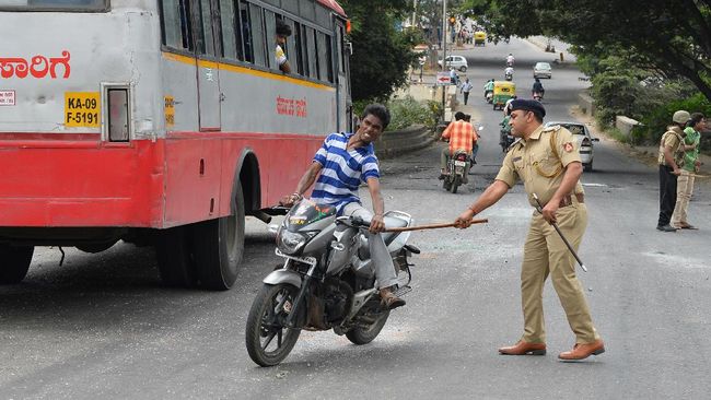 Polisi lalu lintas menilang para pengendara sepeda motor yang tidak menggunakan helm