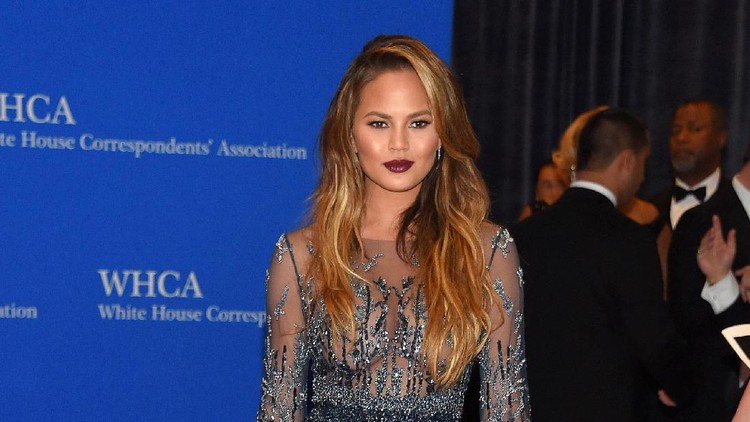 Chrissy Teigen sedang liburan di Bali. Dia memaanfaatkan liburannya untuk belajar menggendong si kecil menggunakan kain jarit nih, Bun.