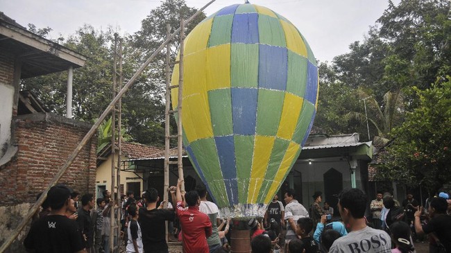 Warga menerbangkan balon udara di Desa Bandung, Kecamatan Diwek, Kabupaten Jombang, Jawa Timur, Minggu (2/7). Tradisi menerbangkan balon udara raksasa bersamaan di tiap musholah ini untuk merayakan Lebaran Ketupat atau biasa disebut Kupatan. ANTARA FOTO/Syaiful Arif/ama/17
